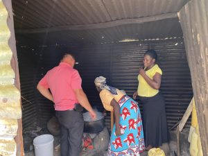 Pastor Micheal learning how to cook the rice over the open flame.